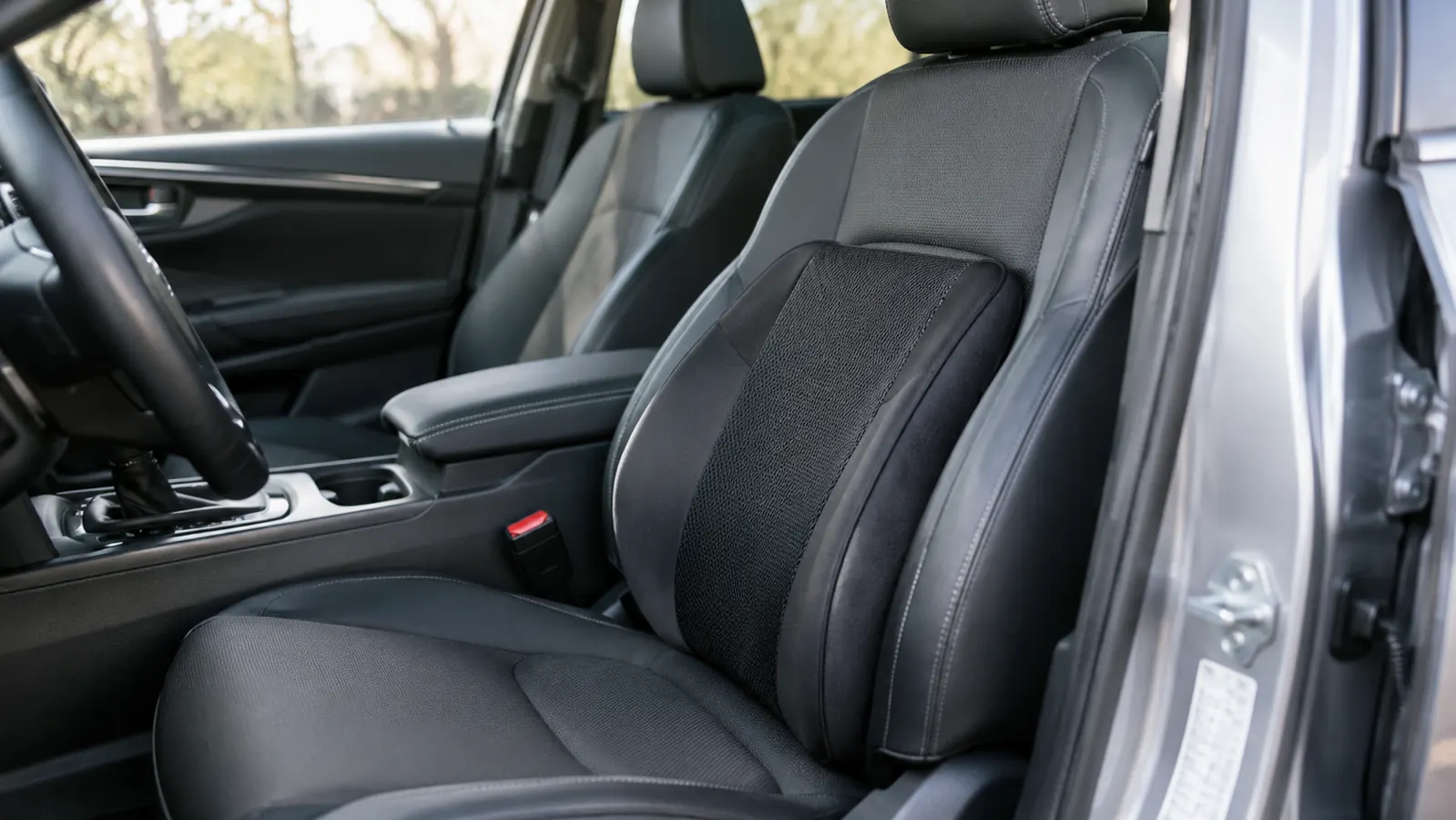 A lumbar support pillow resting on the front seat of a compact SUV, seen from the open door